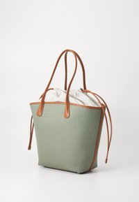 Grønn lerrets totebag med brune skinnakenter og doble håndtak; har snor-lukking og glatt tekstur.