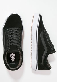 Baskets en daim noir à lacets avec semelles en caoutchouc blanches et doublure à carreaux classique. Présente une bande latérale contrastante blanche et une semelle extérieure marron.