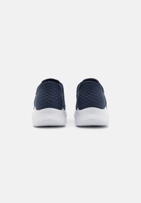 Dunkelblaue Sneaker mit einer strukturierten Oberseite und einer leichten weißen Sohle. Verfügt über ein Slips-on-Design und minimale Nähte an der Rückseite.