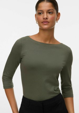 Olijfgroene longsleeve top met een bootneck, gladde textuur, slim fit ontwerp en driekwartmouwen, gecombineerd met zwarte, op maat gemaakte broeken.