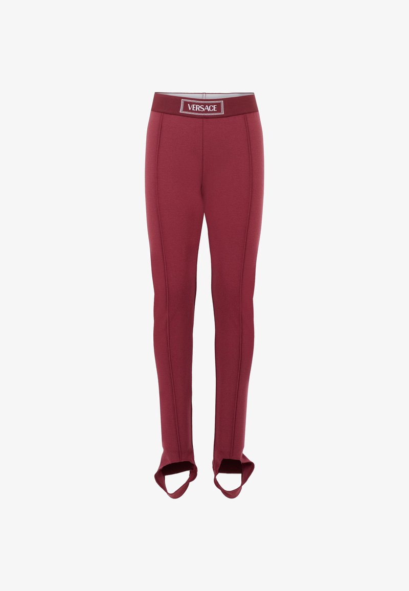 Pantaloni attillati bordeaux con sottopiedi, dettagli con cuciture frontali e una cintura elastica con logo "Versace."