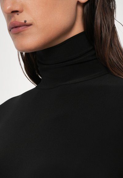Črna turtleneck majica iz gladkega, elastičnega materiala. Ima visok ovratnik in prilegajočo se zasnovo, ki poudarja eleganten videz in čiste linije.