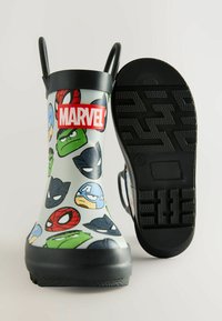 Bottes de pluie en caoutchouc avec une finition brillante, arborant une base grise ornée de visages colorés de super-héros Marvel et d'un logo rouge. Semelles noires avec un motif antidérapant.