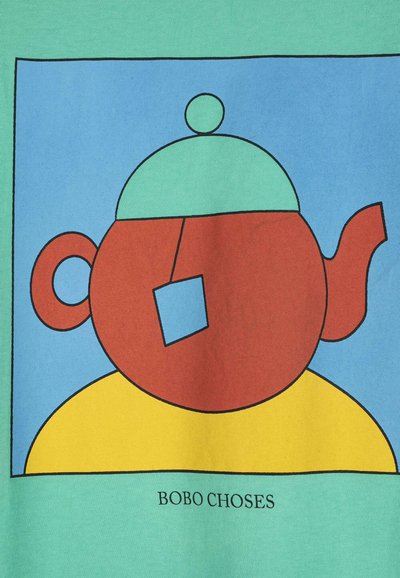 Théière rouge avec couvercle vert et étiquette bleue sur une surface jaune, sur fond bleu et vert, avec le texte « BOBO CHOSES » en dessous.