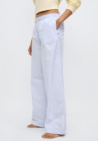 Ελαφριά μπλε και λευκή ριγέ παντελόνια σαλόνι με ελαστική μέση και πλαϊνές τσέπες, με ίσια γραμμή και απαλή υφή υφάσματος.