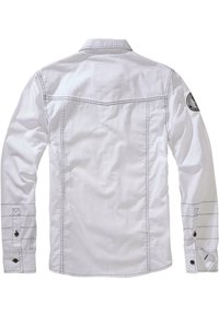 White long-sleeve shirt with a collar, featuring contrasting stitching, buttoned cuffs, and a round patch on the left shoulder.