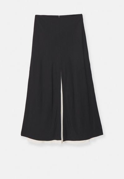 Black wide-leg trousers with a front split, featuring a smooth texture and a contrasting white lining at the hem. Back zipper closure.