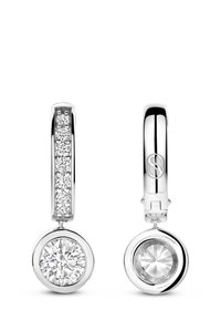 Silberne Creolen mit einem großen runden klaren Edelstein-Anhänger und kleineren Edelsteinen, die entlang der Ohrringe eingelegt sind.