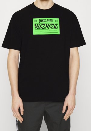 Black cotton t-shirt featuring a bright green graphic design on the front, with a rectangular shape and short sleeves.