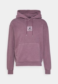Sudadera con capucha en púrpura suave, hecha de tela blanda. Con un bolsillo frontal y un parche con el logo en el pecho, con cordón y puños acanalados.