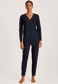 Marine loungewear set bestaande uit een lang mouwtop met kantafwerking op de V-hals en de mouwen, gecombineerd met aansluitende broek. Gladde textuur.