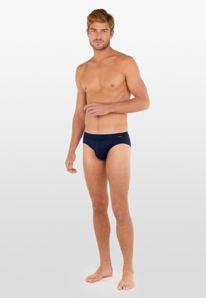 Námořnické modré slipy vyrobené z měkké tkaniny, s nízkým pasem. Jednoduchý pas se minimálním označením, vhodné pro každodenní nošení.