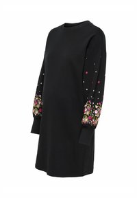 Černé mikinové šaty s dlouhými rukávy a květinovou výšivkou v růžové a zelené barvě. Hladká textura a kulatý výstřih. Ležérní střih.