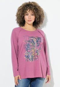 Top a maniche lunghe con colletto rotondo di color viola chiaro, con una grafica colorata che presenta la parola "DANCE" in lettere grassetto.