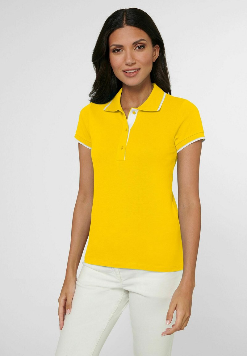 Geel poloshirt met een witte kraag en mouwboorden, met een klassieke pasvorm en een zachte textuur. Draag het met lichtgekleurde broeken.