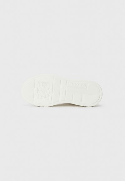 Vit sneakersula med texturerat gummimönster. Har plyschkanter, logotyp präglad och spår för grepp. Slät matt yta.