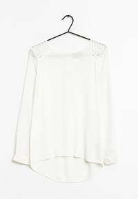Hvid langærmet bluse med ensartet krop og teksturerede, mønstrede ærmer. Rundet kant, tætsiddende manchetter og et afslappet halsudskæring design.