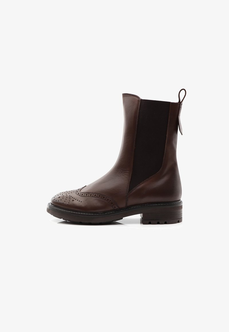 Bruna läderankelboots med elastiska paneler, broguedetaljer på tån och en dragflik. Platt gummisula och något texturerade sidopaneler.