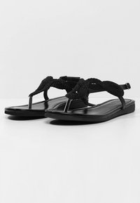 Sorte flade sandaler med et fletstrop-design, tåpost og ankelstøtte. Fremstillet af syntetiske materialer med en glat overflade.