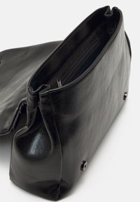 Borsa in ecopelle nera con forma strutturata, chiusura con zip superiore e tasca interna. Texture liscia, design minimalista e dettagli in metallo argentato.