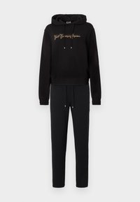 Μαύρη φούτερ με κουκούλα με χρυσά γράμματα και κορδόνια, σετ με ταιριαστό μαύρο παντελόνι φόρμας. Και τα δύο κατασκευασμένα από απαλό ύφασμα, με ριμπ μανσέτες και ζώνη μέσης.