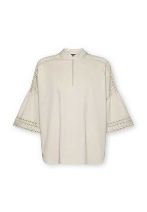 Beige bluse med nøglehulsudskæring, flagrende ærmer og blonde detaljer langs skuldre og ærmekanter.