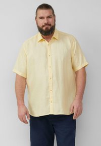 Korte mouwen gele linnen shirt met een knoopsluiting ontwerp. Heeft een zachte textuur en een rechte zoom, gecombineerd met marineblauwe broek.
