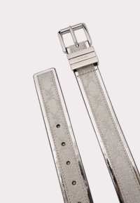 Sølv glimmer faux læderbælte med en skinnende metalspænde, der har flere huller til justering og et slankt, fladt design.
