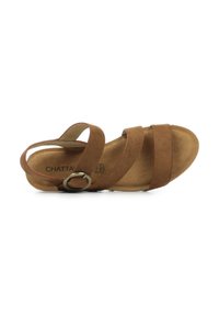 Sandale en suede marron avec trois larges sangles et une boucle en métal circulaire. Semelle intérieure rembourrée et forme contournée pour le confort.