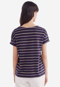 Stribet t-shirt med marineblå, lys pink og gule striber, lavet af blødt stof, med rund halsudskæring og korte ærmer.