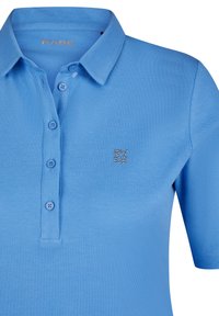 Hellblaues Polohemd aus strukturiertem Stoff mit einer Dreiknopfleiste und einem kleinen Strasslogo auf der linken Brust.