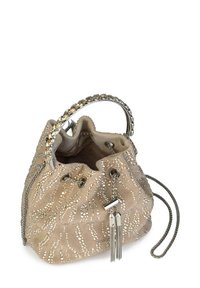 Beżowa zamszowa torba w kształcie wiadra z metalowym łańcuszkiem, zdobieniami i frędzlami. Okrągły kształt z zaciąganym zamknięciem.
