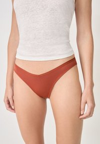 Braune gerippte Bikinihose mit einem glatten Bund, die ein niedrig geschnittenes Design und minimale Abdeckung bietet. Weicher Stoff.