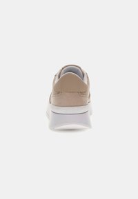 Sneaker in suede beige e pelle liscia con suola in gomma bianca, dotato di collare imbottito alla caviglia e discreto dettaglio del logo in rilievo.