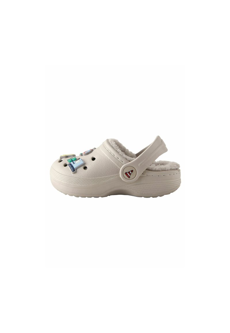 Zoccolo bianco, con texture e fodera pelosa, cinturino posteriore regolabile e charm decorativi colorati sul davanti. Punta arrotondata e suola spessa.