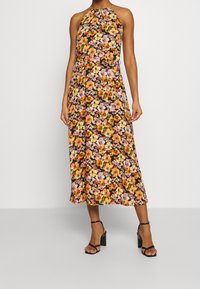 Vestido de tirantes con estampado floral que presenta una base negra con flores rosas, naranjas y amarillas, de corte A-line hasta la rodilla y con una textura suave.