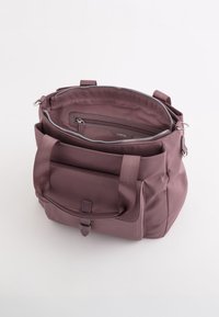 Bolso de nylon morado con dos asas superiores, un compartimento principal con cremallera, un bolsillo delantero y un bolsillo interior con cremallera. Textura suave y mate.