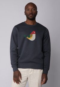 Marineblauw crewneck sweatshirt met een kleurrijke vogelafbeelding op de voorkant, gemaakt van zachte stof met ribgebreide boorden en onderrand.