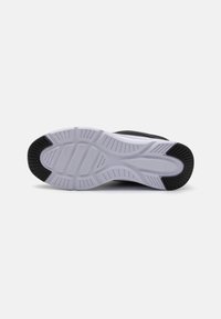 Semelle de chaussure de sport en noir et blanc avec un motif en caoutchouc texturé. Dispose d'un talon plus épais et d'un avant lisse et plat pour une meilleure adhérence.