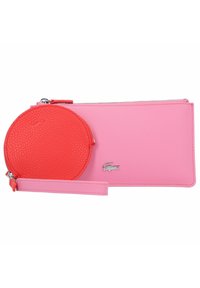 Un ensemble de poche comprenant un porte-monnaie rectangulaire rose et un porte-monnaie rond rouge, tous deux en matériau synthétique texturé, avec un accent de logo argenté.