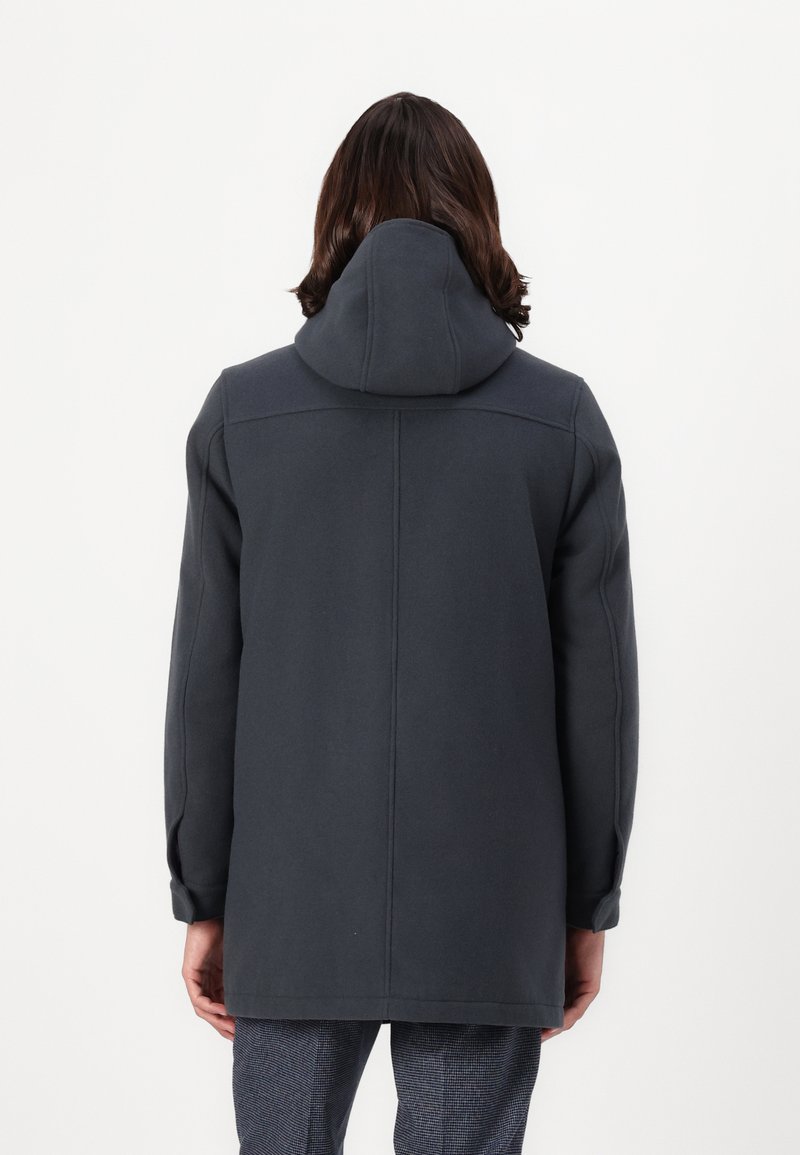 Cappotto grigio scuro con cappuccio e vestibilità ampia. Realizzato in tessuto morbido, presenta cuciture minime e ha una silhouette dritta. Vista posteriore mostrata.