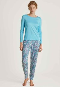 Lichtblauwe lange mouwtop gecombineerd met een patroonbroek met paisley draaikolk in blauw, roze en wit. Zachte stof en slim fit.