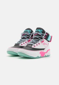 Baskets montantes avec des accents noirs, blancs et roses, dotées d'une semelle cyan, d'un col rembourré et de lacets colorés. Détail de sangle notable à la cheville.