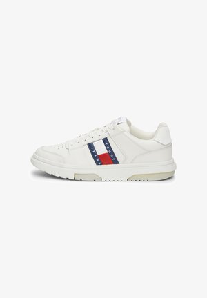 Sneakers bianchi in pelle con finitura testurizzata, caratterizzati da strisce orizzontali rosse e blu e suola in gomma. Design minimalista con chiusura a lacci.