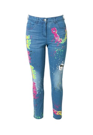 Denim jeans med slim fit, der har flerfarvede grafiske mønstre og sprøjt i pink, gul og grøn på en lys blå baggrund.
