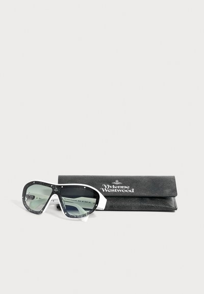 Lunettes de soleil Vivienne Westwood noir et blanc avec des verres verts semi-transparents à côté d’un étui en cuir noir marqué Vivienne Westwood.