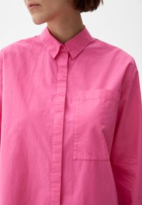 Roze overhemd met knopen in een lichtgewicht stof, voorzien van een kraag en een borstzak. Heeft een gladde textuur en een rechte snit.