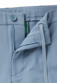 Light blue shorts featuring a button closure, zippered fly, drawstring, and side pocket with visible stitching and smooth fabric texture.