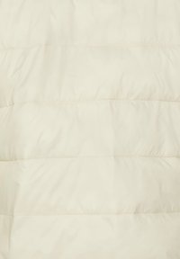 Puffer jacket in gebroken wit met gearceerde secties, voorzien van een gladde, zachte textuur en horizontale stiksels voor isolatie.
