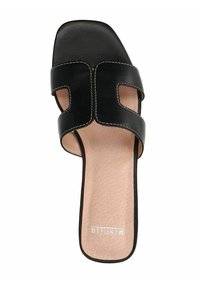 Black leather slide sandal with two cut-out straps, contrasting white stitching, and a textured beige insole. Flat rubber sole for comfort.